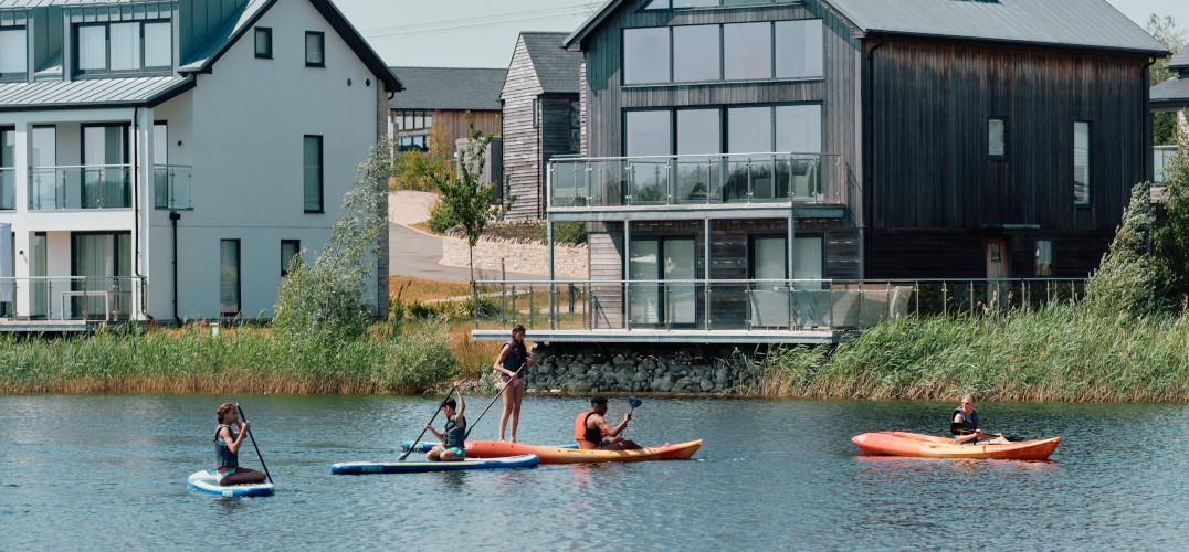 Children kayaking in the water in front of Silverlake lakeside lodges